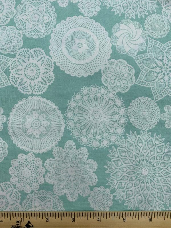 White doilies on an aqua background quilting fabric