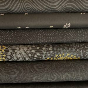 A pile of black quilting fabrics