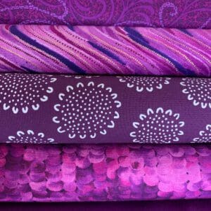A pile of purple quilting fabrics
