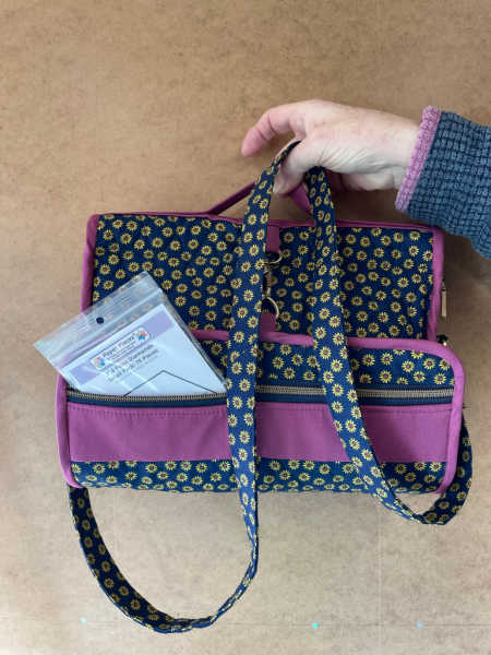 Travel Essentials bag folded up showing straps and outside pocket
