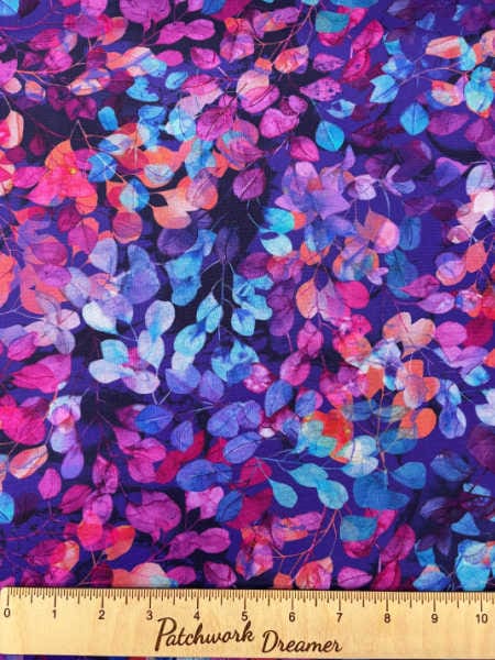 Leaves in orange and teal on a purple background from Dragon Fly Dance Collection by Deborah Edwards and Melanie Samra for Northcott UK