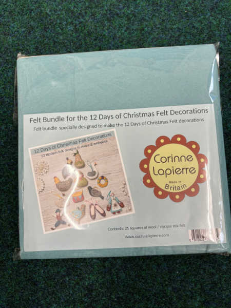 Pack of Corinne Lapierre felt squares for 12 Days of Christmas Felt Decorations book, showing 25 colourful wool-mix pieces in packaging with the book cover image.