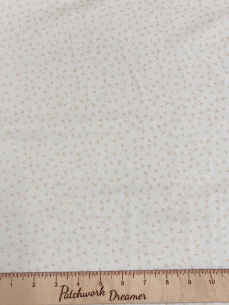 Clothworks UK Guess How Much I Love You cream quilting fabric with tiny floating dandelion seeds scattered across a soft cream background.