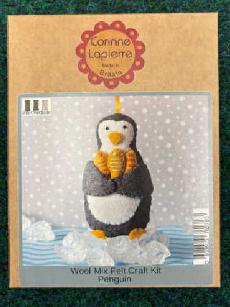 Corinne Lapierre Penguin felt craft kit showing a handmade felt penguin with orange feet and flippers standing on an icy background.