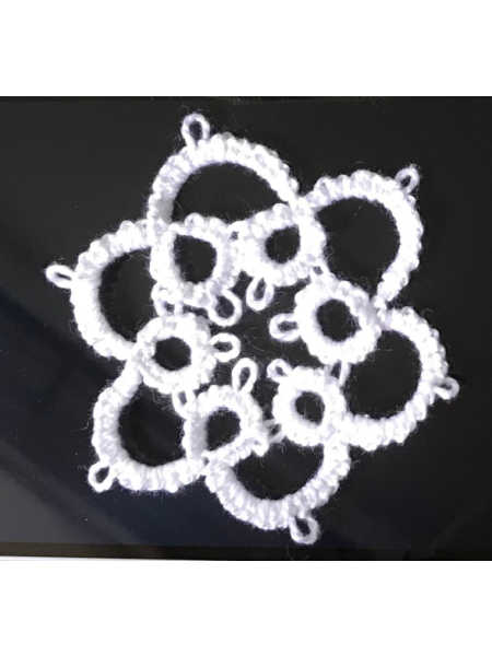 A delicate white tatted lace flower motif with picots, created using a shuttle and perle cotton during the Beginners Tatting Class at Patchwork Dreamer in Bodmin, Cornwall.