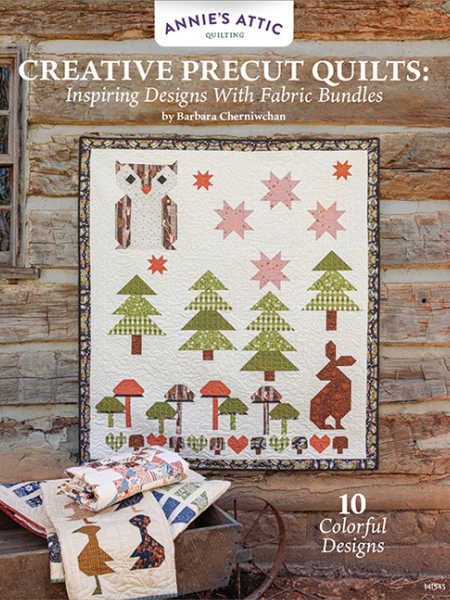Cover of Creative Pre-cut Quilts: Inspiring Designs With Fabric Bundles by Barbara Cherniwchan, showing a woodland-themed quilt hanging on a rustic log wall.