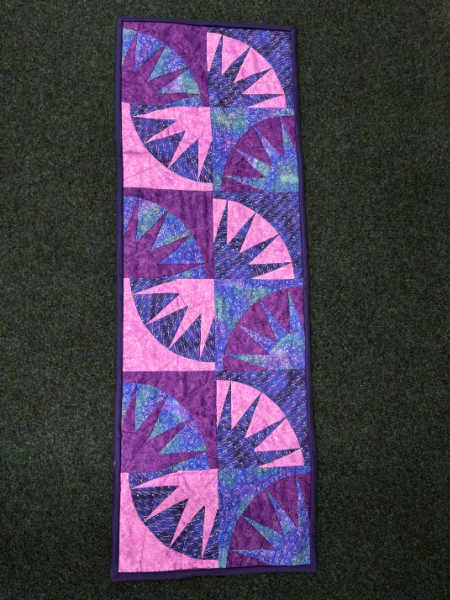 New York Beauty foundation pieced table runner in pink purple and blue fabrics made using Stitch and Tear