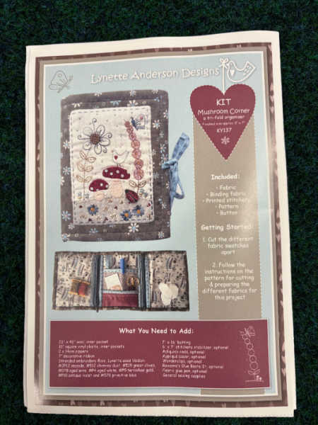 Mushroom Corner sewing kit by Lynette Anderson Designs showing a fabric needle case with embroidered mushrooms, flowers and insects in soft woodland colours, UK.