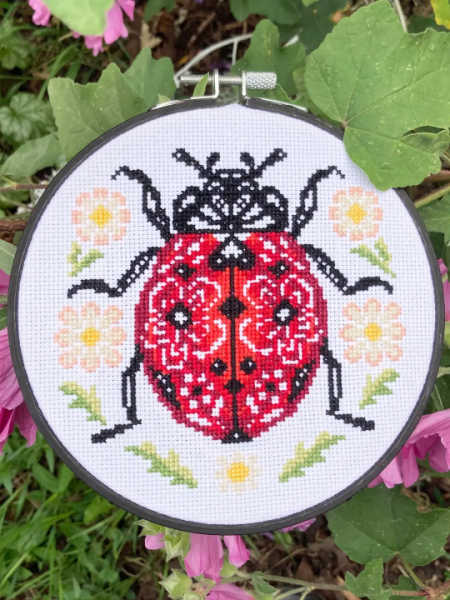 Love Poppet UK Lil’ Ladybird counted cross stitch design with flowers and green leaves