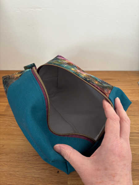 Open Densa Dopp Kit showing spacious pale grey lined interior